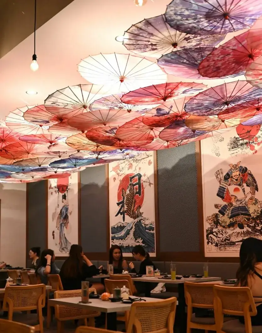 天井いっぱいに和傘が飾られた寿司店の客席